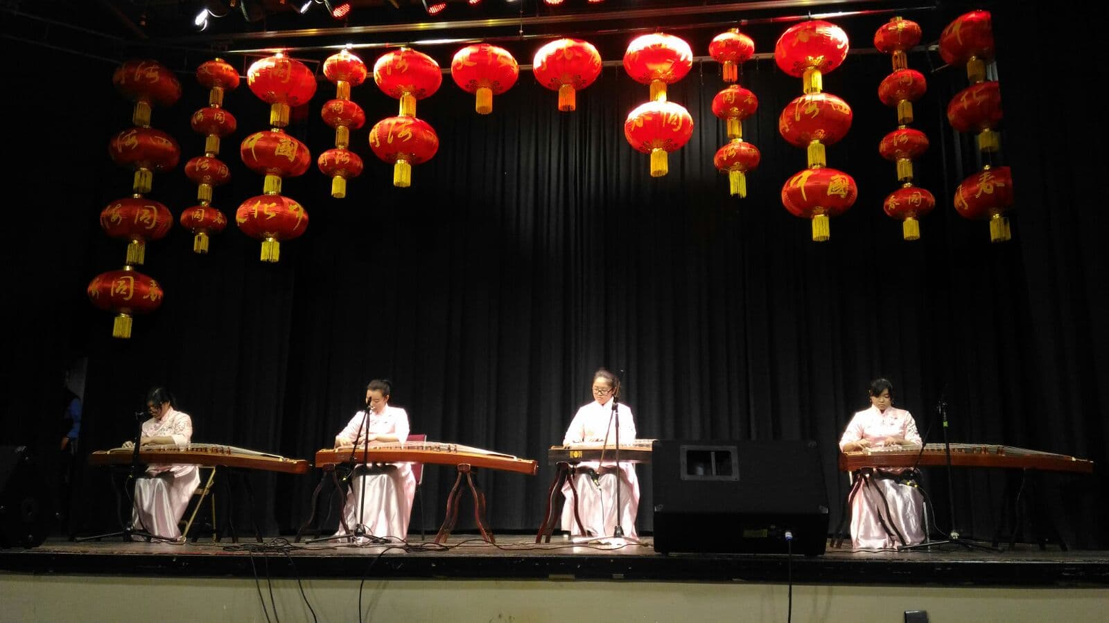 Guzheng ensemble performing under red lanterns